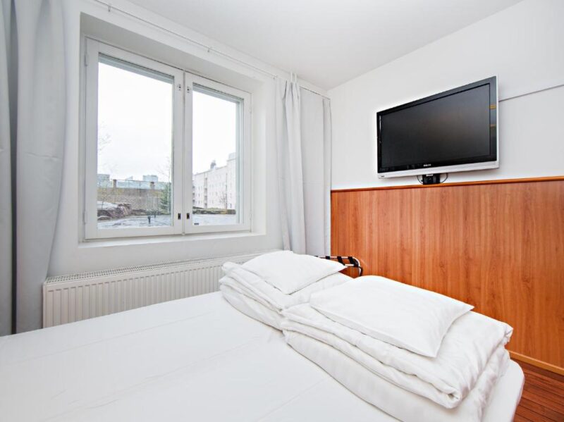 Двуспальная кровать в номере отеля Omena в Турку